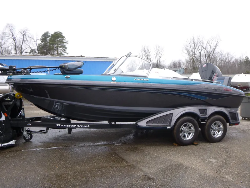 Slide: The Image of 2024 Ranger 1880MS boat on trailer, blue and black design, parked outdoors. - 0