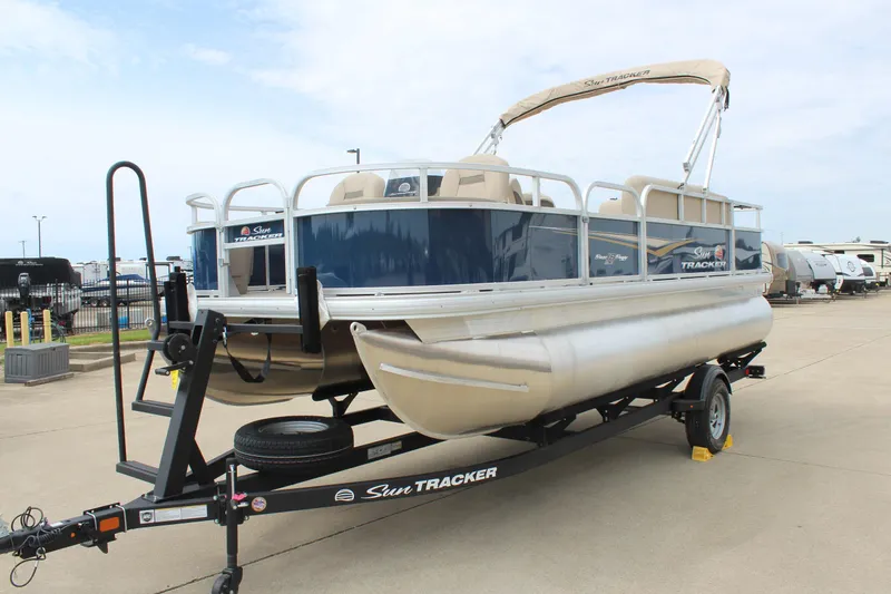 Slide: The Image of 2025 Sun Tracker Bass Buggy 18 DLX pontoon boat on trailer, outdoor display. - 3