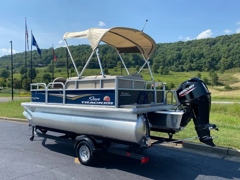 Slide: The Image of 2025 Sun Tracker Bass Buggy 16 XL Select pontoon boat with canopy and Mercury outboard motor. - 4