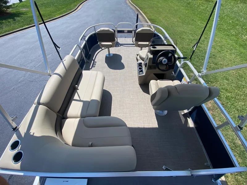 Slide: The Image of 2025 Sun Tracker Bass Buggy 16 XL Select pontoon boat interior with beige seating and steering console. - 8
