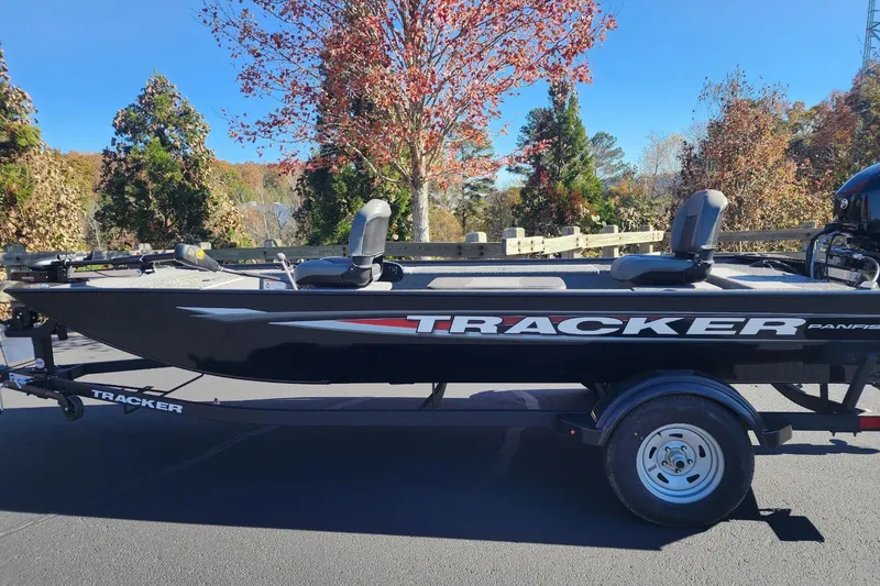 The Image of 2025 Tracker Panfish 17 boat on trailer, parked outdoors with autumn trees in background. - 0