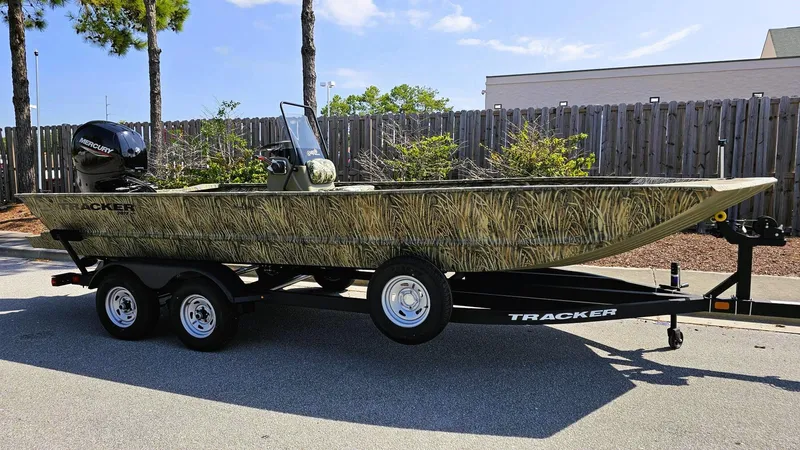 Slide: The Image of 2025 Tracker Grizzly 2072 CC boat on trailer, camo design, parked outdoors. - 5