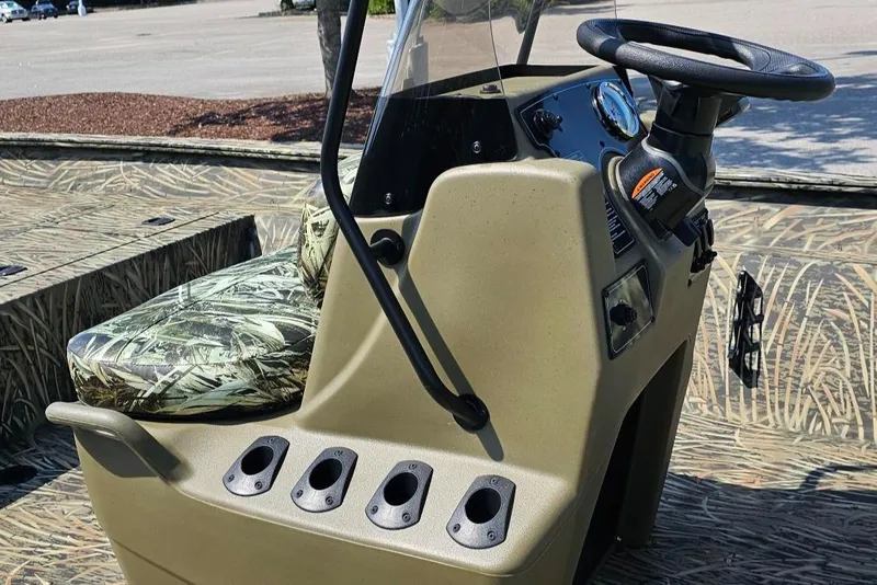 Slide: The Image of 2025 Tracker Grizzly 2072 CC boat console with camouflage seating and steering wheel. - 8