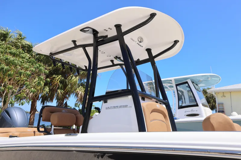 Slide: The Image of 2023 Sea Hunt Ultra 219 boat with T-top, palm trees in background. - 10