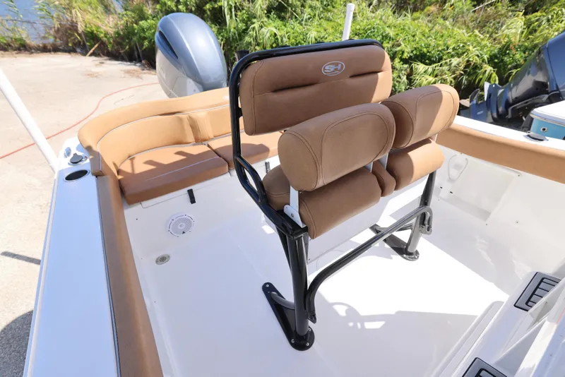 Slide: The Image of 2023 Sea Hunt Ultra 219 boat interior with cushioned seating and motor. - 3