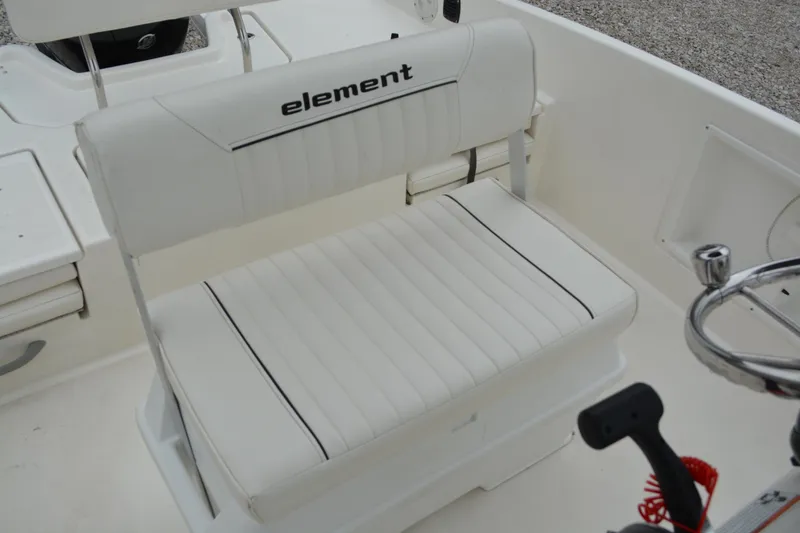 Slide: The Image of 2021 Bayliner Element F21 boat seat with white upholstery and steering wheel. - 14