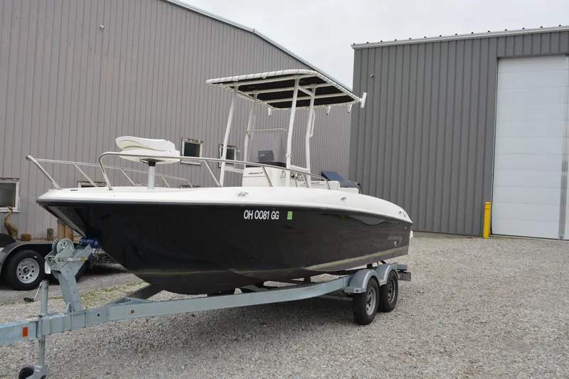 Slide: The Image of 2021 Bayliner Element F21 boat on trailer near industrial building. - 2