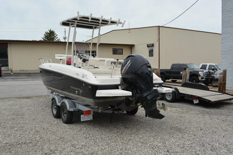 Slide: The Image of 2021 Bayliner Element F21 boat on trailer, parked on gravel lot. - 4