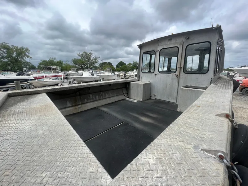 Slide: The Image of Custom Flat 28 Cabin Boat, 2010 model, with spacious deck and cabin, under cloudy skies. - 9