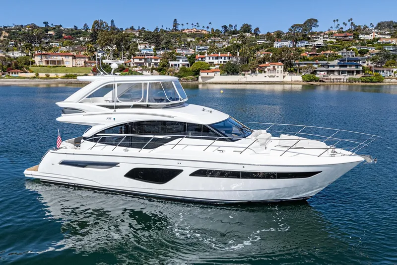 Slide: The Image of 2022 Princess F55 yacht cruising near scenic coastal homes. - 12