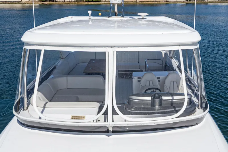 Slide: The Image of 2022 Princess F55 yacht with spacious seating and helm, docked on calm water. - 17