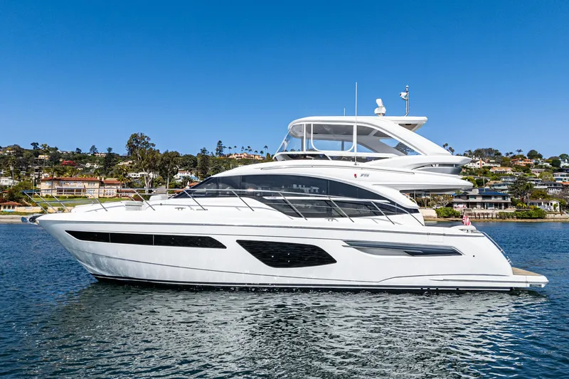 Slide: The Image of Luxury 2022 Princess F55 yacht cruising on a sunny day near coastal homes. - 2