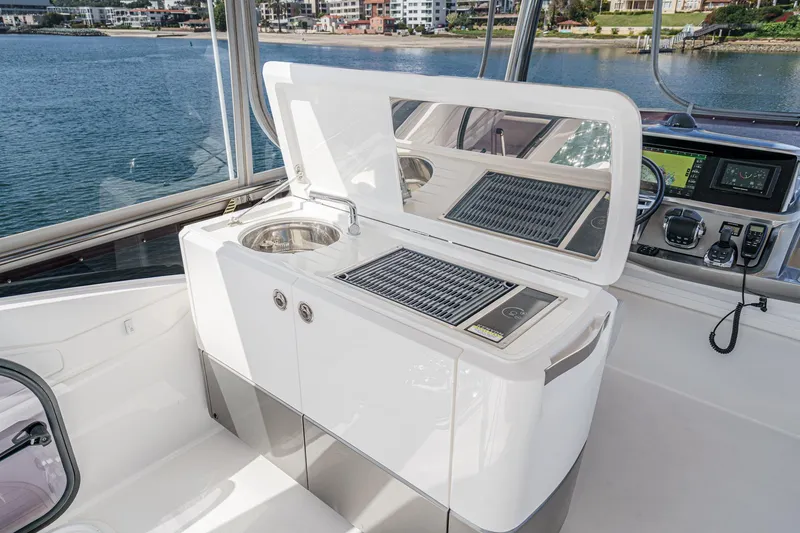 Slide: The Image of Luxury yacht Princess F55 2022 with sleek outdoor kitchen and scenic waterfront view. - 22