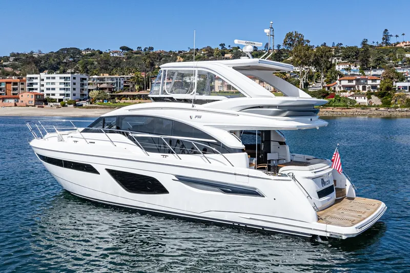 Slide: The Image of 2022 Princess F55 yacht cruising near coastal residential area. - 3