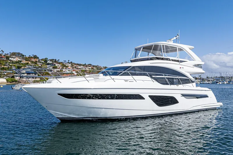 Slide: The Image of Luxury 2022 Princess F55 yacht cruising on a sunny day near coastal homes. - 5