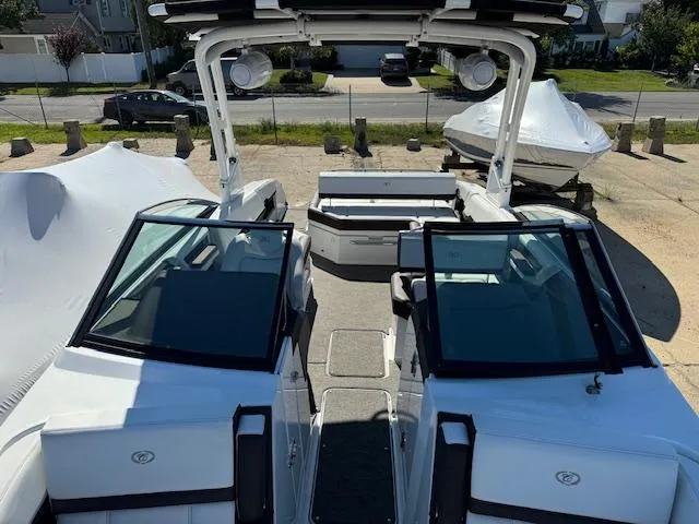 Slide: The Image of 2021 Cobalt R8 boat interior with dual consoles and seating, parked outdoors. - 11