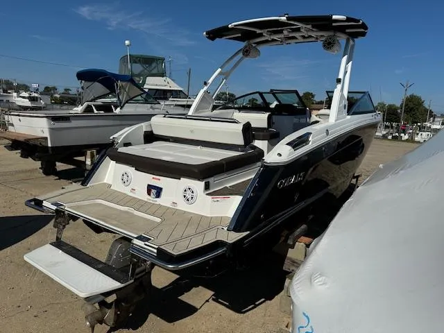 Slide: The Image of 2021 Cobalt R8 boat with sleek design, docked in a marina under clear blue skies. - 2