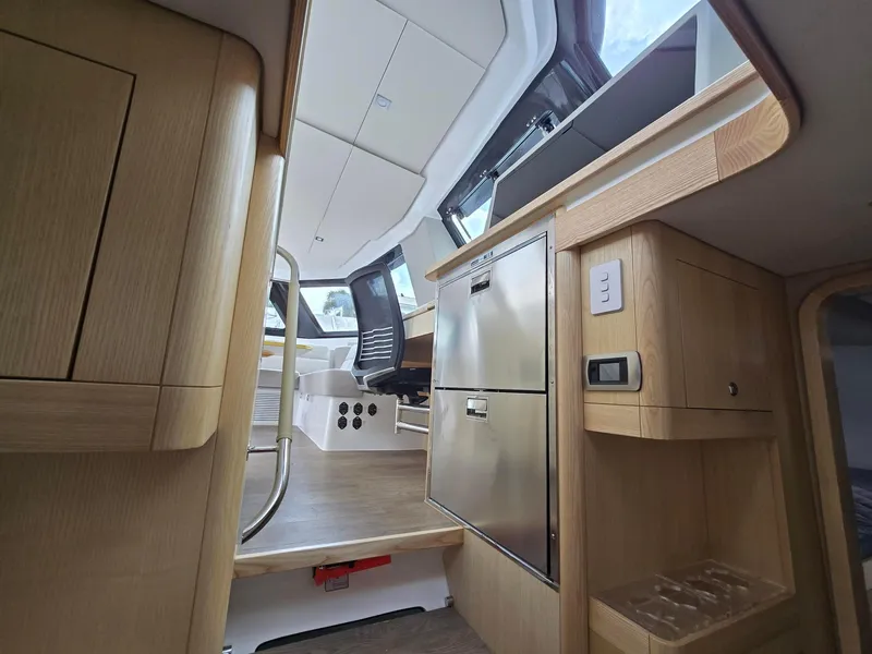 Slide: The Image of Interior of 2025 Seawind 1370 yacht, featuring modern kitchen and seating area. - 18