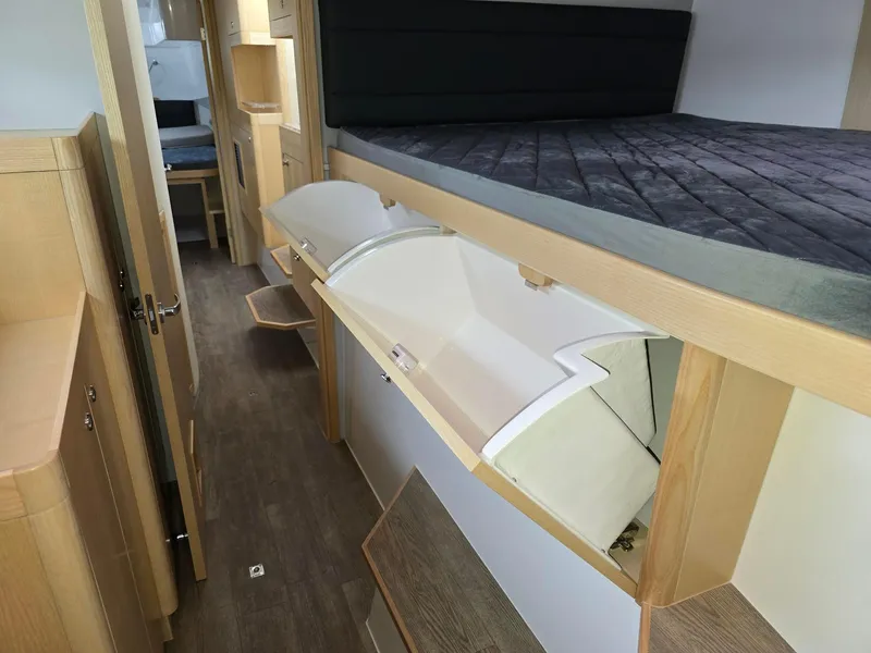 Slide: The Image of Interior of 2025 Seawind 1370 yacht, featuring modern wood finish and storage compartments. - 20