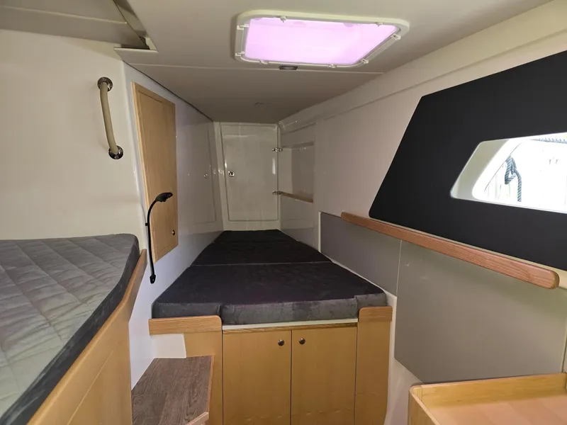 Slide: The Image of 2025 Seawind 1370 cabin interior with bed, storage, and window. - 21