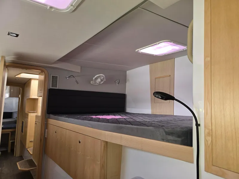 Slide: The Image of Interior of 2025 Seawind 1370 yacht with modern sleeping area and ambient lighting. - 23