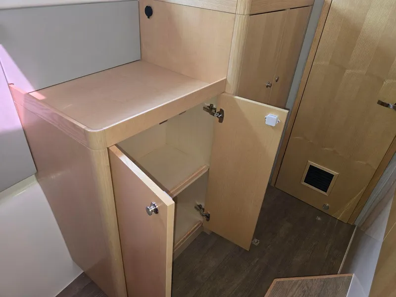 Slide: The Image of Interior storage cabinets on a 2025 Seawind 1370 yacht, featuring light wood finish. - 32