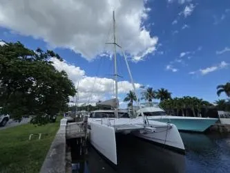 Slide: The Image of 2025 Seawind 1370 catamaran docked under a partly cloudy sky. - 39