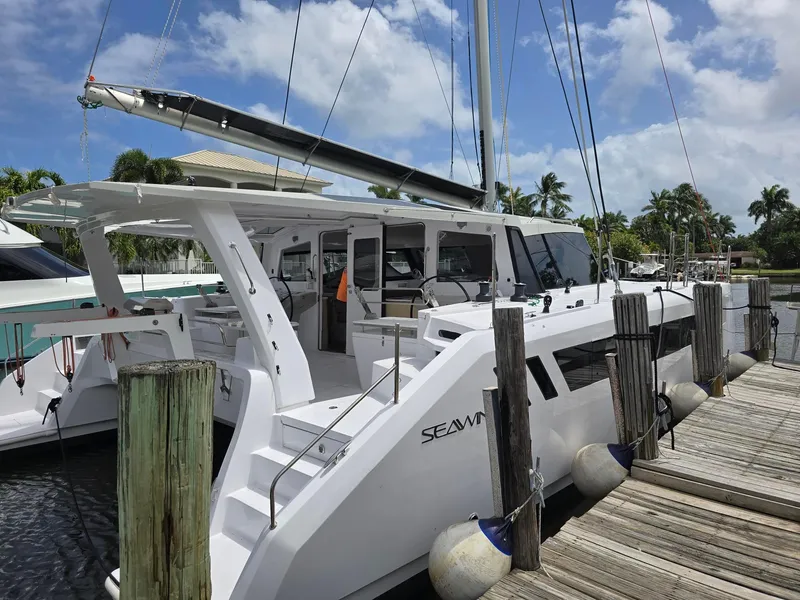 Slide: The Image of 2025 Seawind 1370 catamaran docked at marina under clear blue sky. - 4