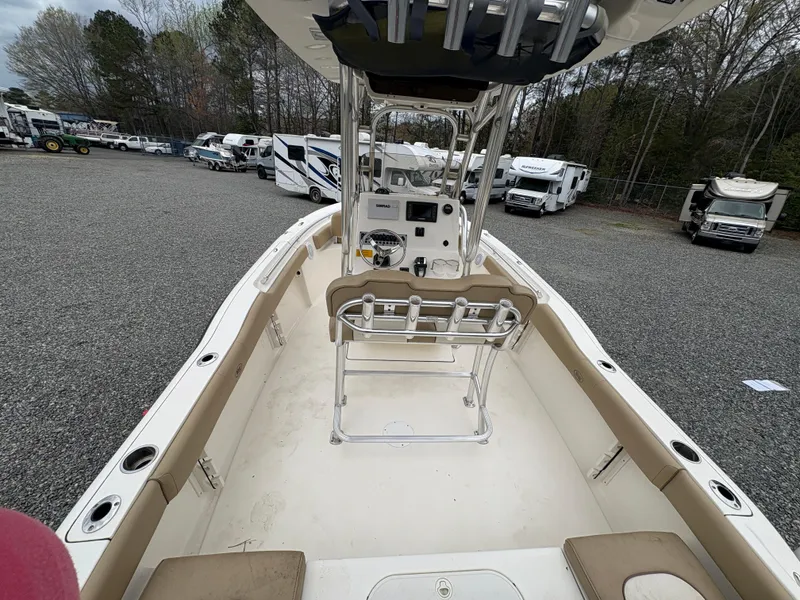 Slide: The Image of 2017 Key West 219fs boat interior with seating and console, parked in a lot with RVs. - 10
