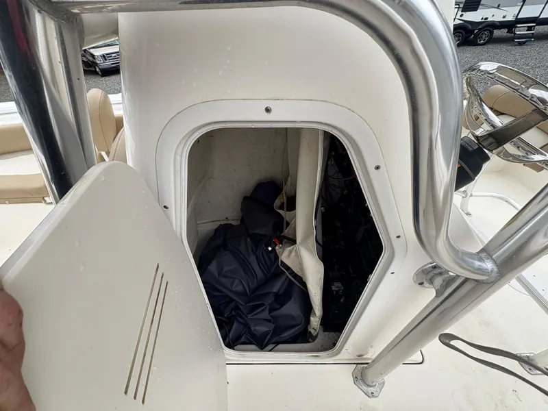 Slide: The Image of 2017 Key West 219fs boat storage compartment with open door and interior items. - 17