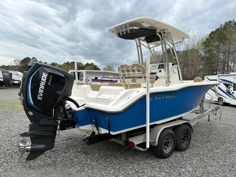 Slide: The Image of 2017 Key West 219fs boat on trailer with Evinrude engine, parked outdoors. - 4