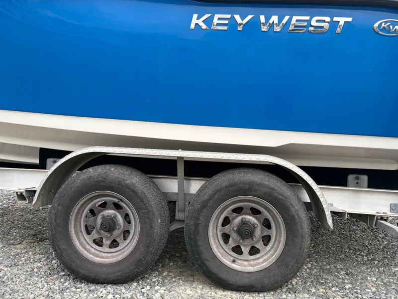 Slide: The Image of 2017 Key West 219fs boat on trailer with dual wheels, blue hull. - 8