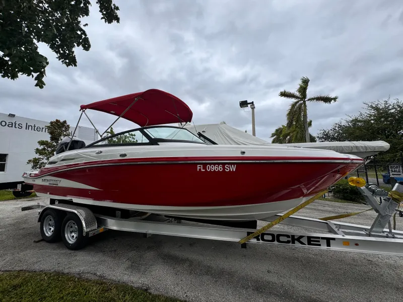 Slide: The Image of Red 2020 Monterey M-45 boat on trailer, parked outdoors under cloudy sky. - 0