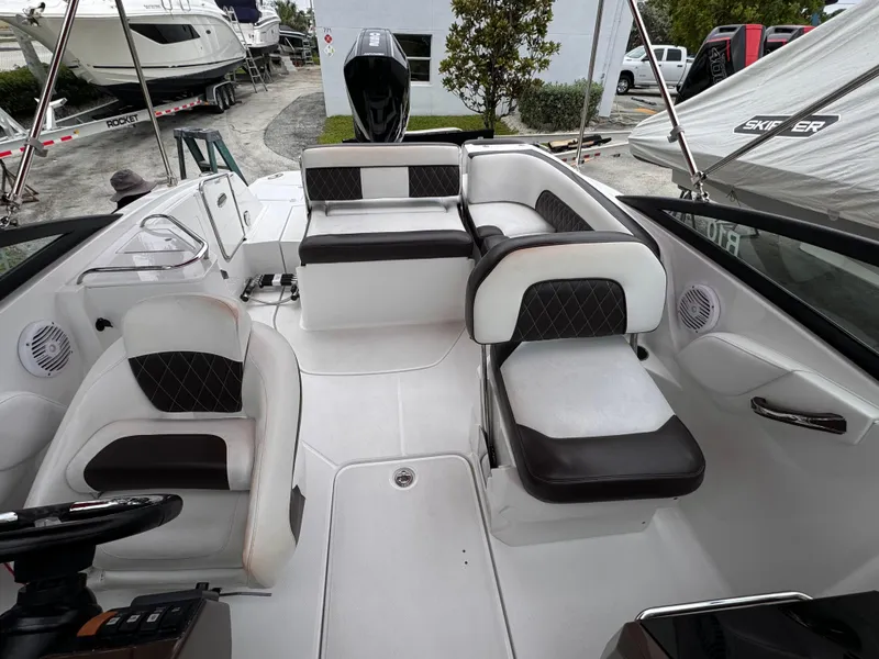 Slide: The Image of 2020 Monterey M-45 boat interior with white and black seating, docked near other boats. - 15