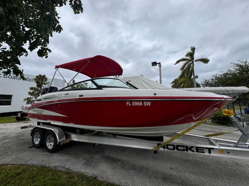 Slide: The Image of Red 2020 Monterey M-45 boat on trailer, parked outdoors under cloudy sky. - 25