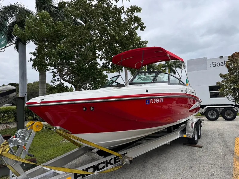 Slide: The Image of Red 2020 Monterey M-45 boat on trailer, parked outdoors with trees in the background. - 26