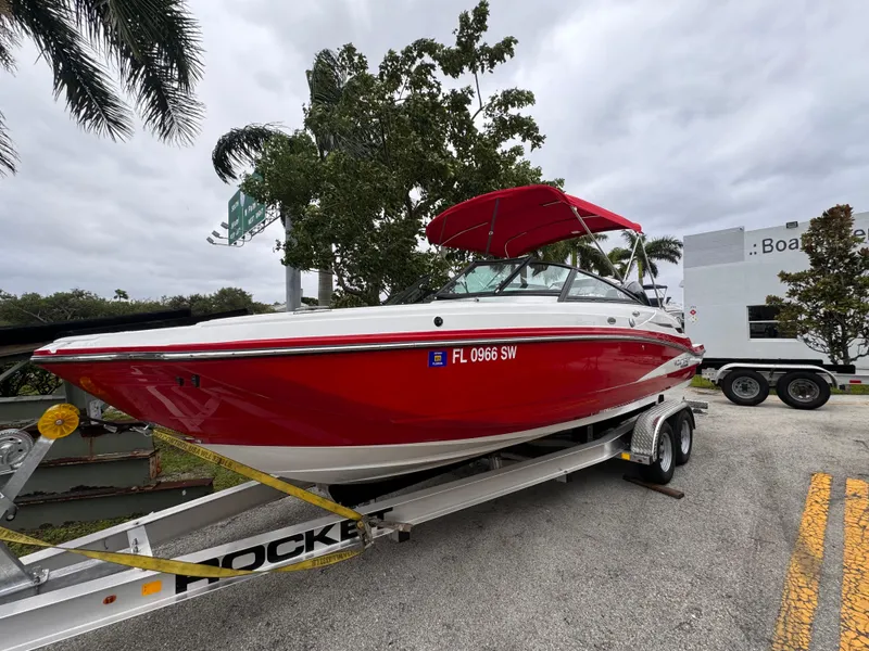 Slide: The Image of Red 2020 Monterey M-45 boat on trailer, parked outdoors with trees and cloudy sky. - 27