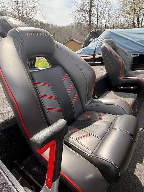 Slide: The Image of 2018 Nitro Z18 boat seats with black and red design, outdoors. - 2