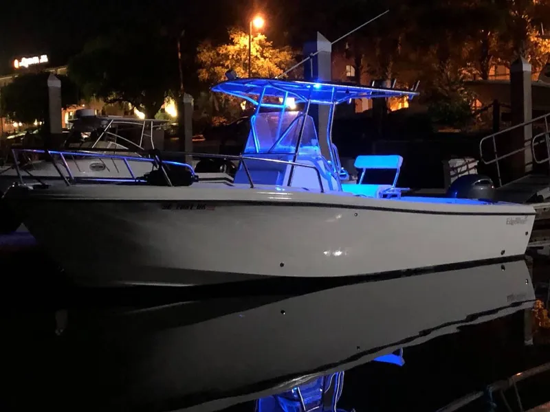 Slide: The Image of Edgewater 225CC 2002 boat illuminated with blue lights at night, docked in a marina. - 1