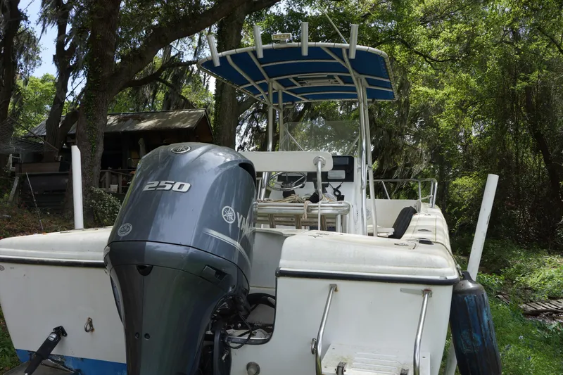 Slide: The Image of 2002 Edgewater 225CC boat with Yamaha 250 engine, parked outdoors under trees. - 11