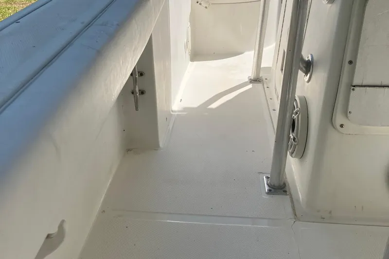 Slide: The Image of 2002 Edgewater 225CC boat interior, featuring clean white deck and side railings. - 5