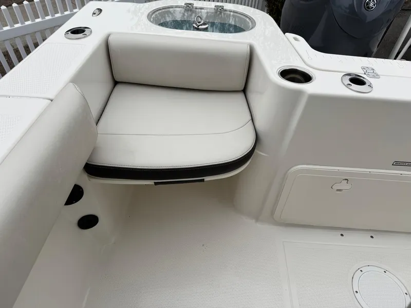 Slide: The Image of 2024 Sailfish 220 CC boat interior with white cushioned seating and storage compartments. - 12