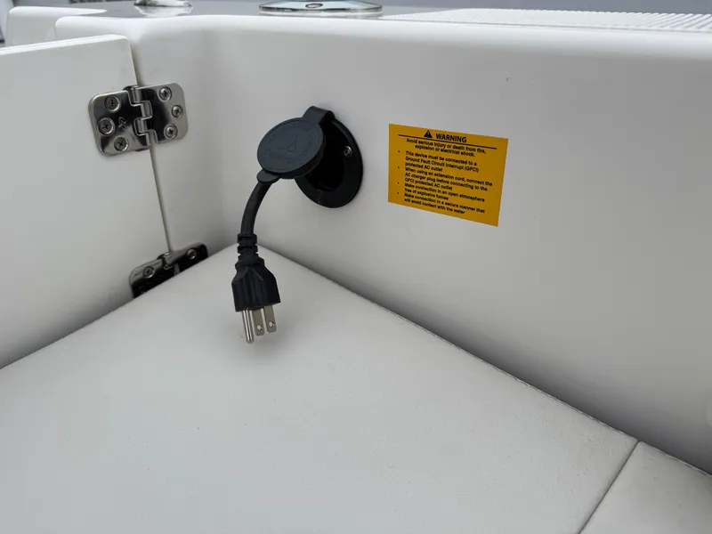 Slide: The Image of 2024 Sailfish 220 CC boat power outlet with warning label. - 18