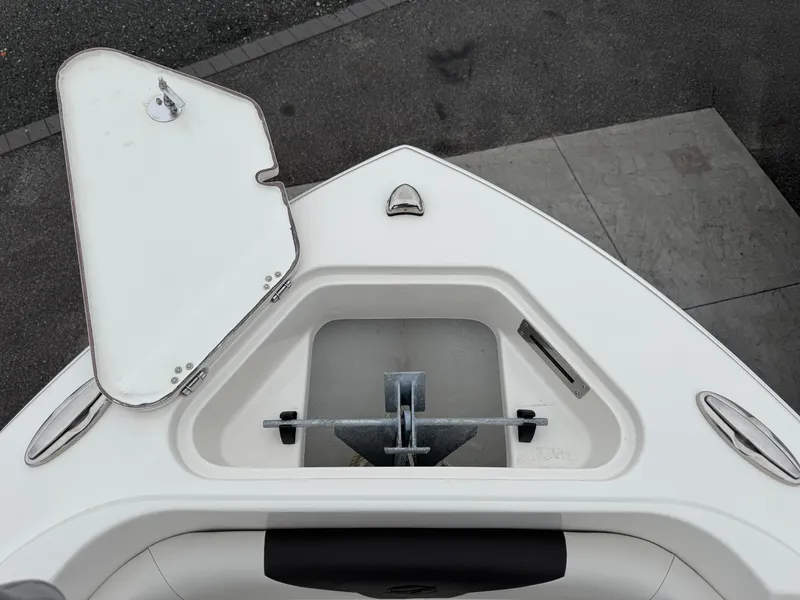 Slide: The Image of 2024 Sailfish 220 CC boat anchor compartment with open hatch, showcasing sleek design. - 7