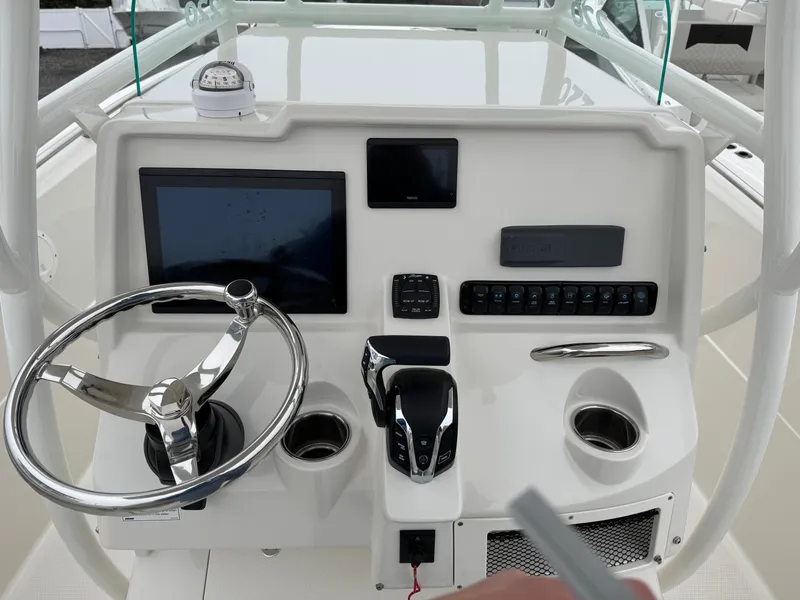 Slide: The Image of 2024 Sailfish 220 CC boat dashboard with steering wheel and electronic controls. - 8