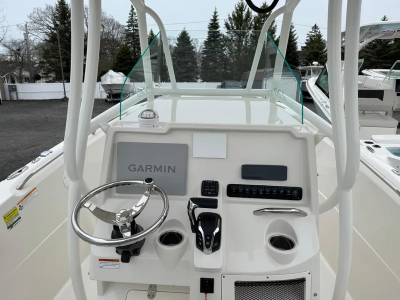 Slide: The Image of 2024 Sailfish 220 CC boat dashboard with Garmin navigation system and steering wheel. - 9