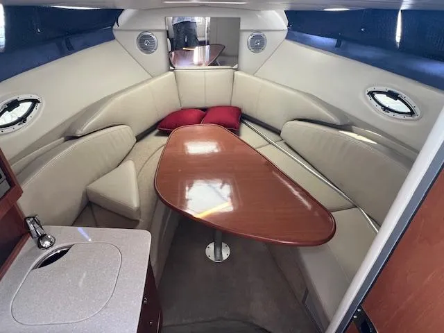 Slide: The Image of Interior of 2009 Bayliner 245 Cruiser with seating, table, and portholes. - 10
