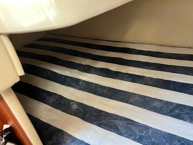 Slide: The Image of Interior cabin of 2009 Bayliner 245 Cruiser with striped bedding. - 14