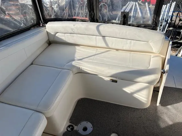 Slide: The Image of 2009 Bayliner 245 Cruiser interior with white cushioned seating and carpeted floor. - 4