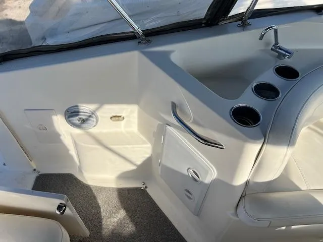 Slide: The Image of 2009 Bayliner 245 Cruiser interior with sink, cup holders, and seating area. - 5